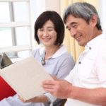 長年連れ添った夫婦が自宅の前で微笑んでいるイメージ・おしどり贈与